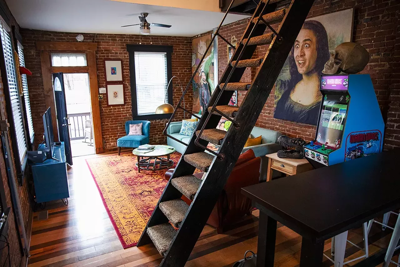 The massive prints of Cage are nothing more than shower curtains stretched over wood that Seline purchased at Home Depot or pulled from a scrap pile.
