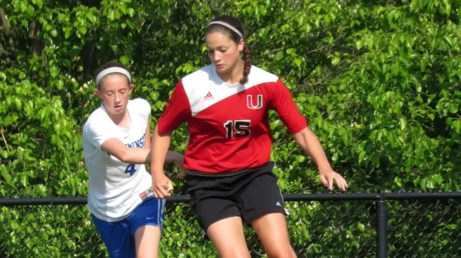 Two women play soccer.