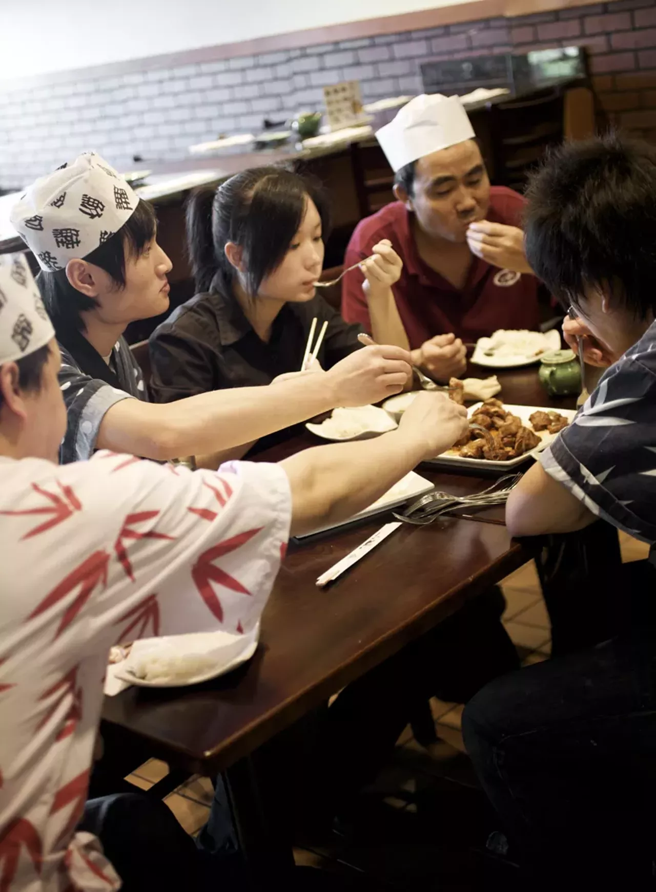 The owners and staff sit down for lunch after the customers have gone.