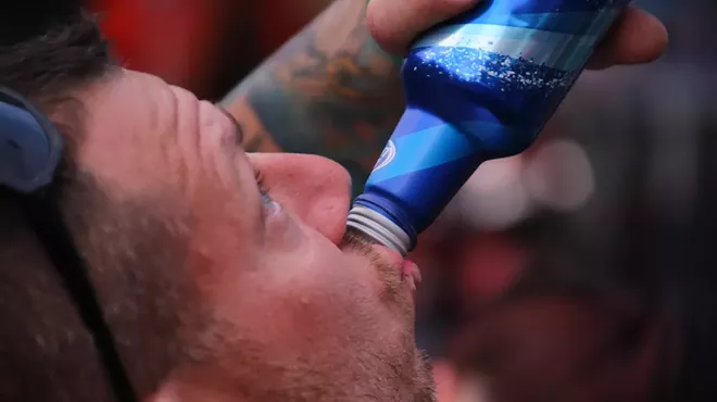 A man drinks Bud Light.