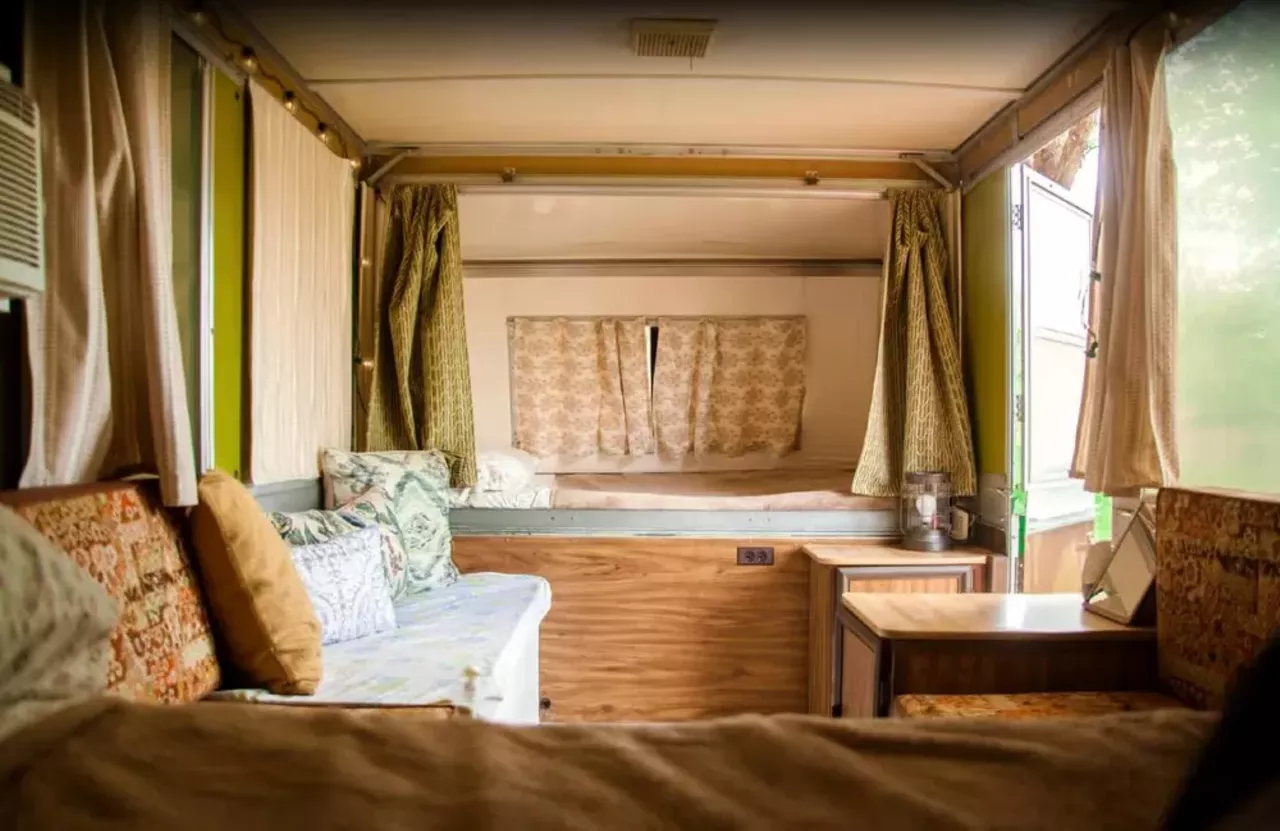 Vintage Camper Rental Ideal for Glamping "The interior boasts a comfy seating area where guests can relax after a busy day exploring the Missouri wilderness. Outside, there's a private outdoor deck where guests can relax and take in the fresh air. Guests can also enjoy a private fire-pit with firewood provided for a truly relaxing place to gather." Book this unit on GlampingHub.com