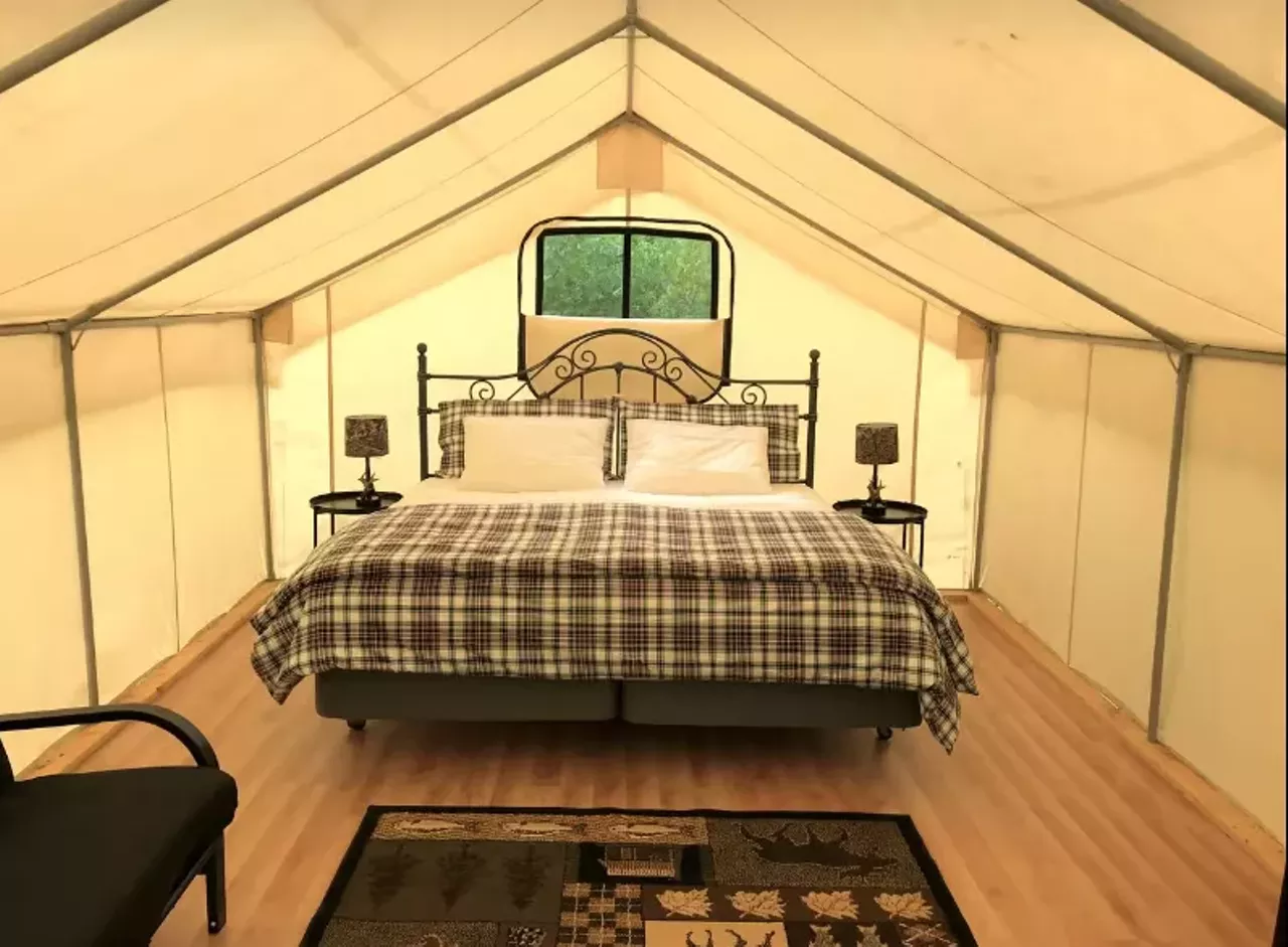 Secluded Safari Tent Rental for Glamping "It features a large Glamping Tent in a private and secluded campsite that is just steps from a hidden pond. The tent features a king bed plus a futon that converts to a full bed for the kids (camp cots are also available for the kids)." Book this unit on GlampingHub.com
