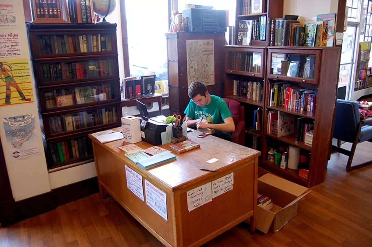 Employee Mark Gould works at the desk. Both employees and regulars may remember the original location in a historic Victorian house. That location closed in 2013, and after some fundraising, the store has been in the current location ever since.