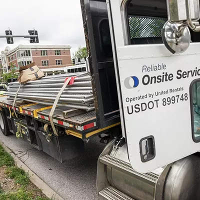 A worker stands near a truck with metal fences near Wash U’s Danforth Campus.