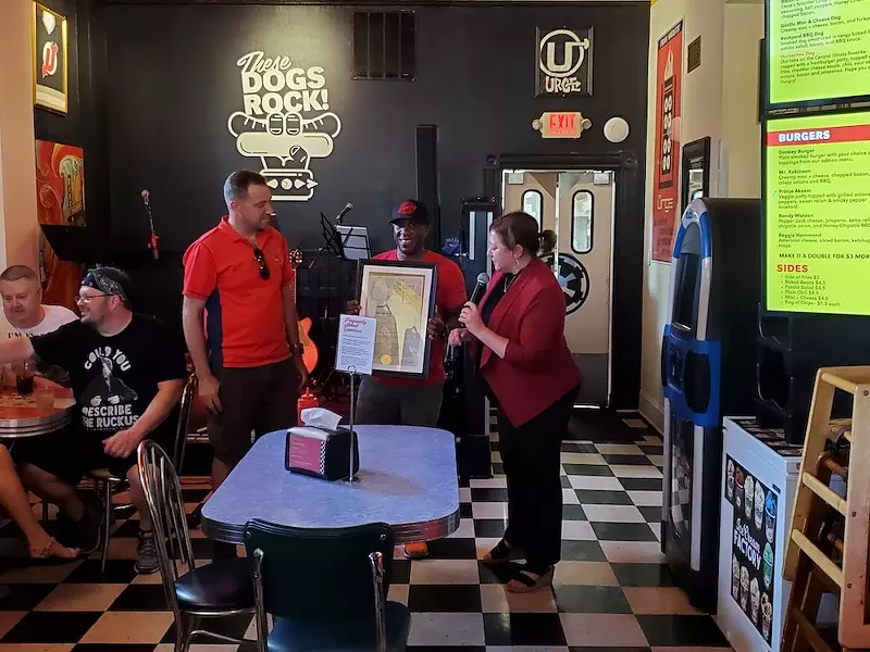 Joseph Zeable (left, standing) and Steve Ewing (center) accept the resolution from Christine Ingrassia. - ROSALIND EARLY